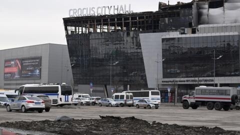 Des voitures de police sont garées devant le Crocus City Hall à Krasnogorsk, dans la banlieue de Moscou, le 29 mars 2024, une semaine après l'attaque qui a fait 144 morts et des dizaines de blessés.