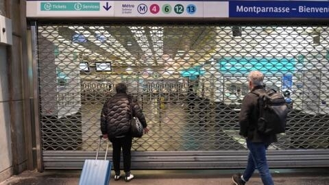 Passageiros esperam diante das portas fechadas da estação de metrô de Montparnasse, durante a greve de 10 de novembro de 2022. 