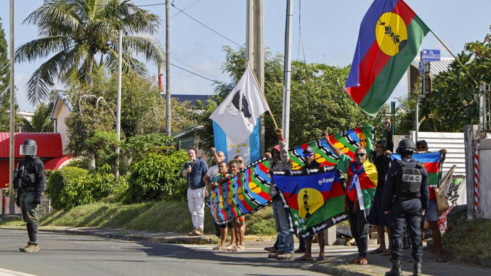 Des personnes manifestent alors que le cortège du président français Emmanuel Macron passe à Nouméa, en Nouvelle-Calédonie, le jeudi 23 mai 2024.