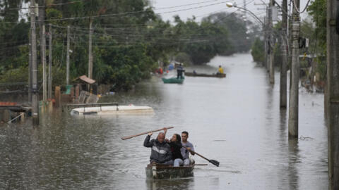 Moradores atravessam de barco uma área inundada de Canoas, no Rio Grande do Sul, em 10 de maio de 2024.