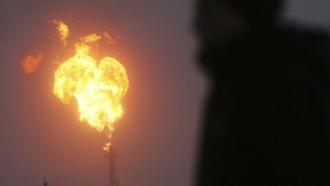 Um homem observa a queima de gás natural em uma instalação da Gazprom na cidade de Novy Urengoi, em 17 de dezembro de 2007.