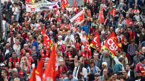 Manifestantes agitam bandeiras da Confederação Geral do Trabalho da França (CGT) durante uma manifestação durante dia de greve nacional convocado pelos representantes inter-sindicais da França para promover aumentos salariais e pedir igualdade entre homens e mulheres em Nantes, oeste da França, em 13 de outubro de 2023.