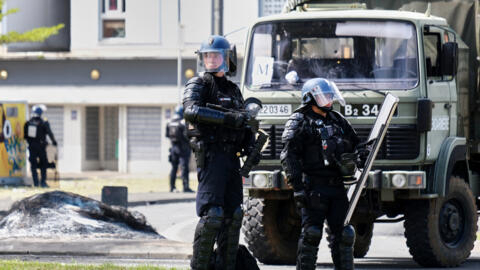 Des gendarmes français gardent l'entrée du quartier de la Vallée-du-Tir, à Nouméa, le 14 mai 2024, lors de manifestations liées à un débat sur un projet de loi constitutionnelle visant à élargir le co