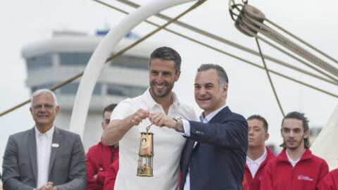 Tony Estanguet, President of Paris 2024, left, and Chairman of the Management Board of BPCE Nicolas Namias hold the Olympic flame during a ceremony before the departure of the Flame to France at the p