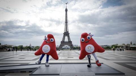 La mascotte des JO et des Palympiques devant la Tour Eiffel.