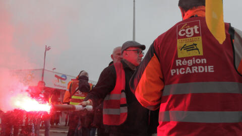 Trabalhadores grevistas com o sindicato CGT na entrada do depósito de óleo da TotalEnergies em 13 de outubro nos arredores de Dunquerque, norte da França.
