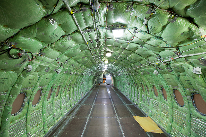Фюзеляж самолета изнутри обит зелеными матами для тепло- и звукоизоляции