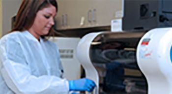 A medical lab worker handling equipment