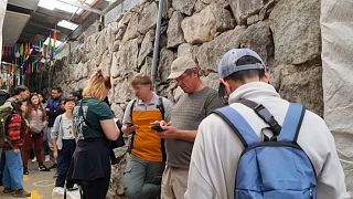 Tourist:innen warten am Bahnhof von Machu Picchu.