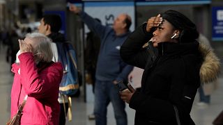 Reisende schauen auf die Anzeigetafel der Züge in der Londoner Waterloo Station