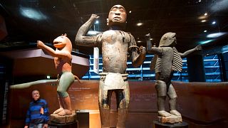 Un visitatore osserva le statue reali in legno del regno Dahomey, nell'attuale Benin, risalenti al XIX secolo, al museo Quai Branly di Parigi nel 2018.