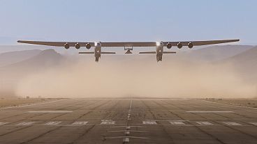 L'avion Roc à six moteurs décolle avec le véhicule d'essai Talon-A-1 attaché sous ses ailes.