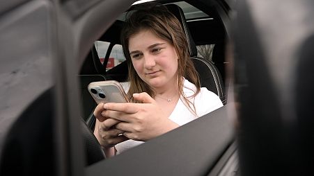 Alexis Bogan, whose speech was impaired by a brain tumour, uses an AI powered smartphone app to create a audible drink order at a Starbucks.