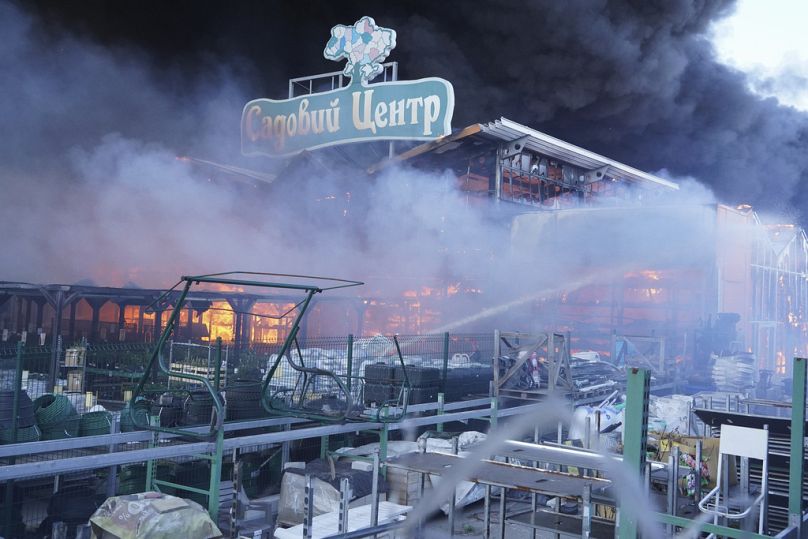 Feuerwehrleute löschen ein Feuer, nachdem zwei Bomben einen Baumarkt in Charkiw, Ukraine, getroffen haben, Samstag, 25. Mai 2024.