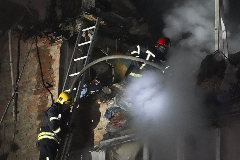 Bombeiros apagam um incêndio num edifício de apartamentos danificado pelo ataque de mísseis russos em Kharkiv, 31 de maio de 2024