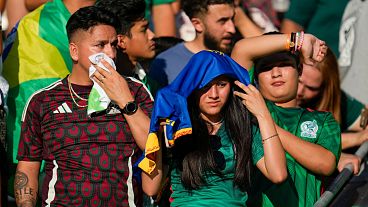 Espectadores aguantan el calor mientras esperan para ver a los jugadores calentar antes de un amistoso internacional de fútbol entre México y Brasil el 8 de junio de 2024, Texas.