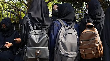 Alumnas esperando delante del colegio con pañuelo en la cabeza