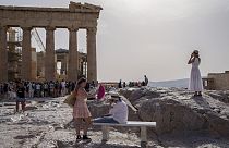 Imagen de varias personas en el espacio turístico de la Acrópolis en Atenas.