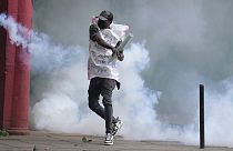 A protester returns back a teargas canister to Kenya police in Nairobi, Kenya Thursday, June 27, 2024.