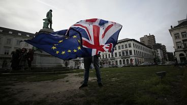 EU-Befürworter Peter Cook entrollt eine Unions- und eine EU-Flagge vor einer Zeremonie zur Feier der Freundschaft zwischen Großbritannien und der EU vor dem Europäischen Parlament in Brüssel.