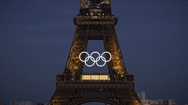 Gli anelli olimpici appesi alla Torre Eiffel