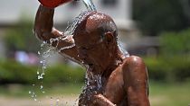 رجل يحاول تخفيض حرارة جسمه خلال يوم صيفي حار في حديقة في كراتشي، باكستان، الثلاثاء 21 مايو/أيار 2024. 