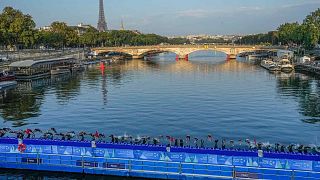 Sportolók a Szajnába merülnek a III. Sándor hídról a 2024-es párizsi olimpia női triatlon tesztversenyének első szakaszán Párizsban, 2023. augusztus 17-én.