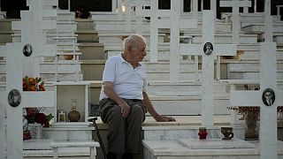 لوكاس ألكسندرو، 94 عامًا، يجلس بجوار قبر ابنه كريستاكيس الذي قُتل أثناء الغزو التركي، قبرص، الجمعة 19 يوليو 2024. 