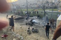 Des habitants se précipitent pour aider des enfants blessés quelques instants après qu'une attaque à la roquette ait touché un terrain de football à Majdal Shams sur le plateau du Golan contrôlé par Israël, le 27 juillet 2024.