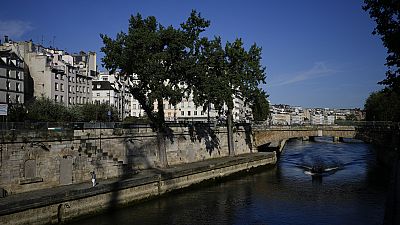 A man walks along the Seine river at the 2024 Summer Olympics, Sunday, July 28, 2024, in Paris, France.