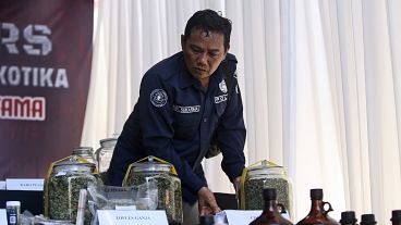 Bir polis memuru bir villada düzenlediği basın toplantısında kanıtları sergiliyor. (Arşiv fotoğraf)