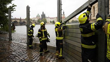 Des pompiers ajustent des parties des barrières anti-inondation à Prague, le 13 septembre 2024.