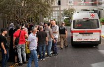 Lebanese Red Cross ambulance passes next of the families of victims who were injured by their exploding handheld pagers.