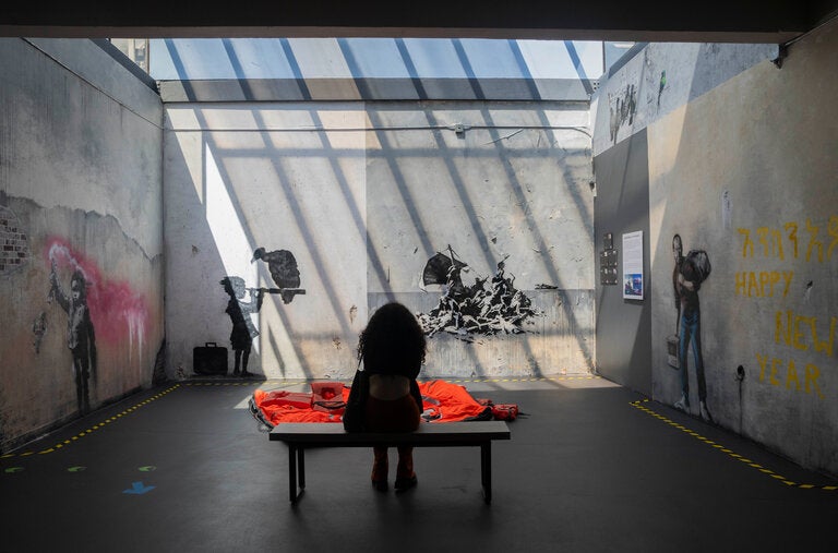 A scene from the Banksy Museum, left to right, with reproductions of “Migrant Child,” 2019, a commentary on the refugee crisis, Venice, Italy; “Child With Vulture,” 2015, Calais, France; “Raft of the Medusa,” 2015, Calais, France; “Steve Jobs — The Son of a Migrant From Syria,” 2015, near Calais, France.
