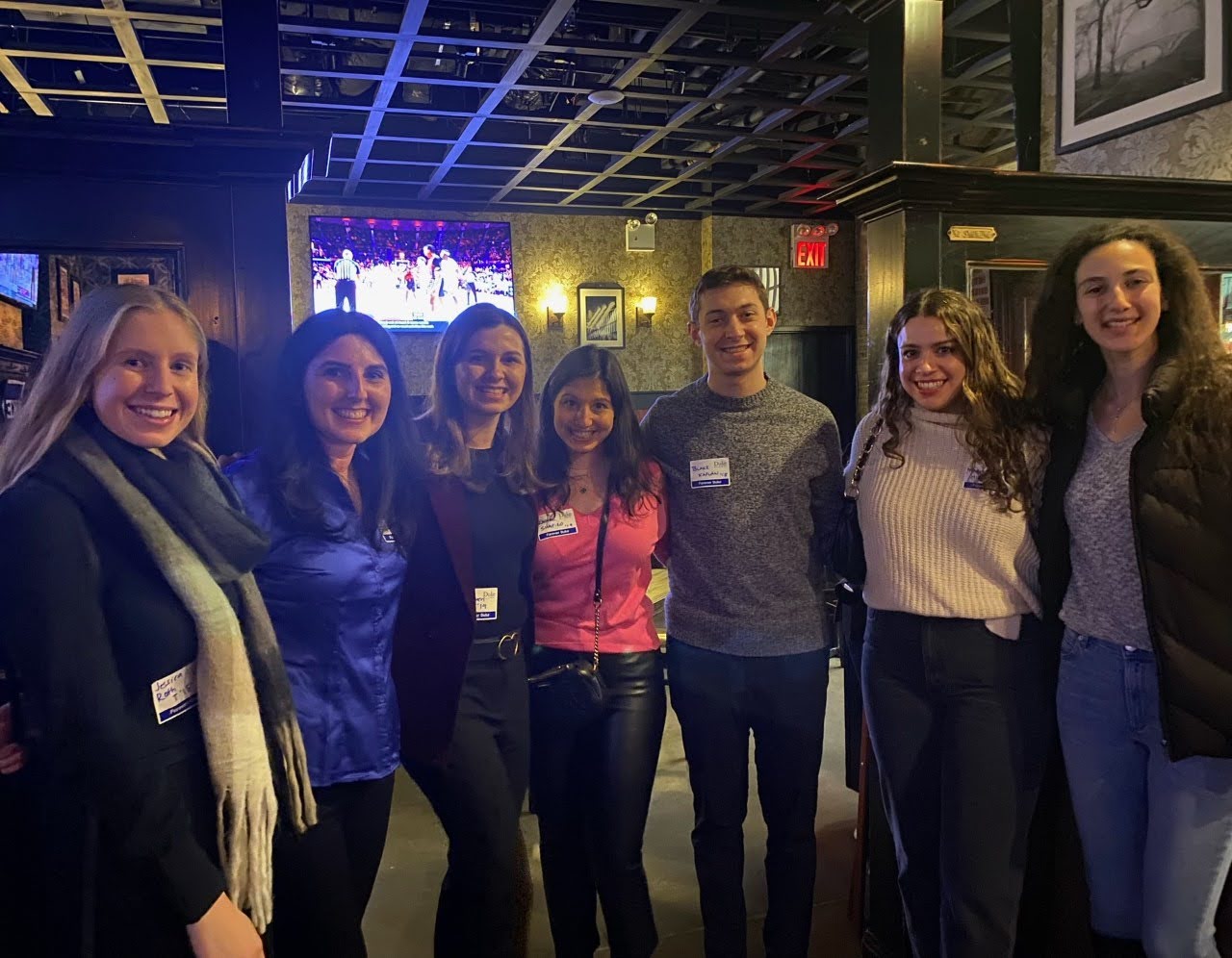 group of alumni pose at a happy hour location