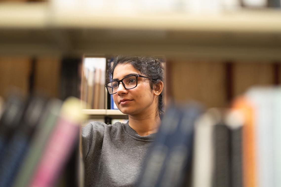 Neeharika looking through books in the library