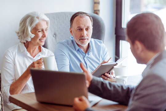 Positive aged couple consulting with insurance agent