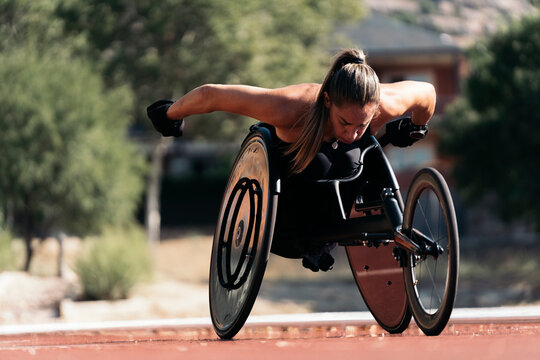 Female wheelchair athlete adjusting her chair on sports track