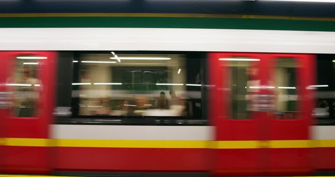 A woman in formal clothes walks along the subway platform. The train is passing by