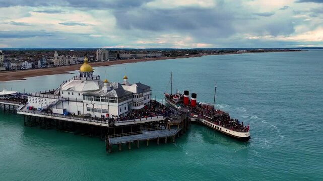 Aerial footage captures Waverley, the world's last sea-going paddle steamer, gracefully docked at the pier.