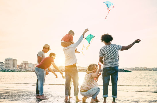 Happy familes flying with kite and having fun on the beach