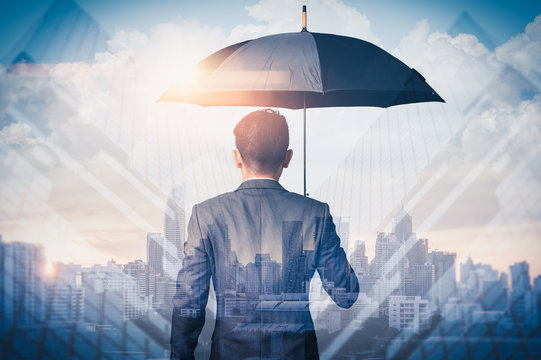 The double exposure image of the Businessmen are spreading umbrella during sunrise overlay with cityscape image. The concept of modern life, business, insurance and protection.