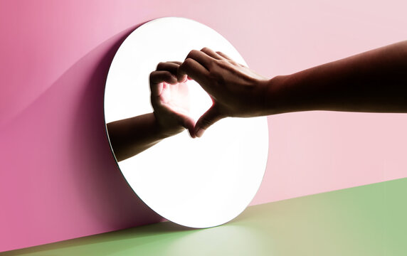 Conceptual Photo for Love and Relationship. Love Yourself. Single Person using Hand to Form a Heart Shape on the Mirror. Fill Yourself with Romance on Valentines Day