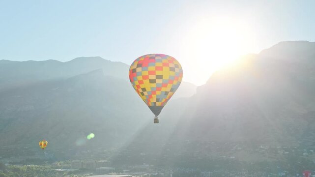 Colorful hot air balloons flying over valley and sunrise - drone shot