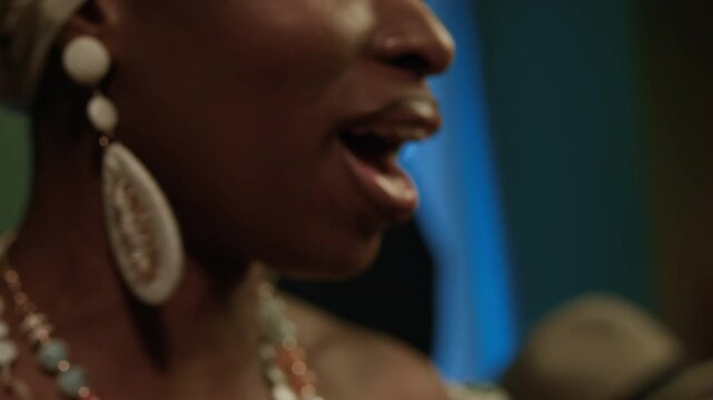 Close up view of face of African American young female vocalist performing in bar with bandmates