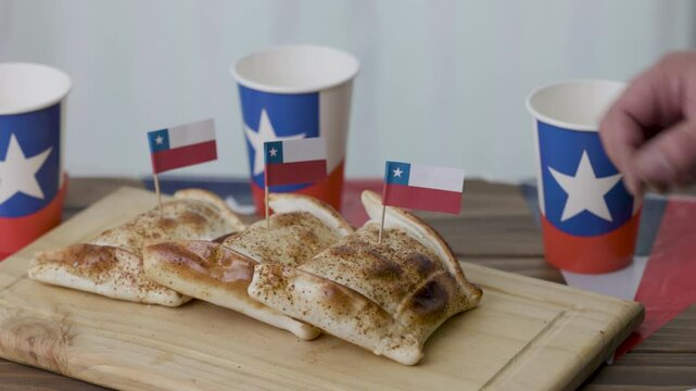 Fiestas Patrias Chile putting up chilean flag to a Empanadas