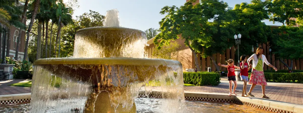 People laughing around a fountain.