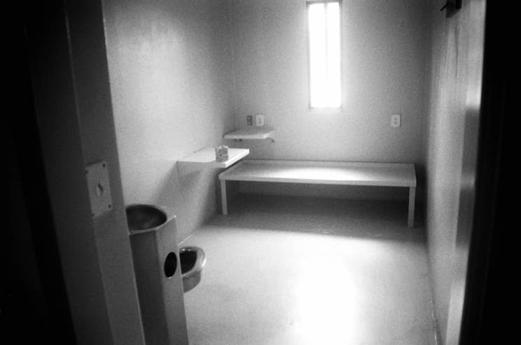 A black and white photo of the interior of an isolation cell at Maine State Prison.