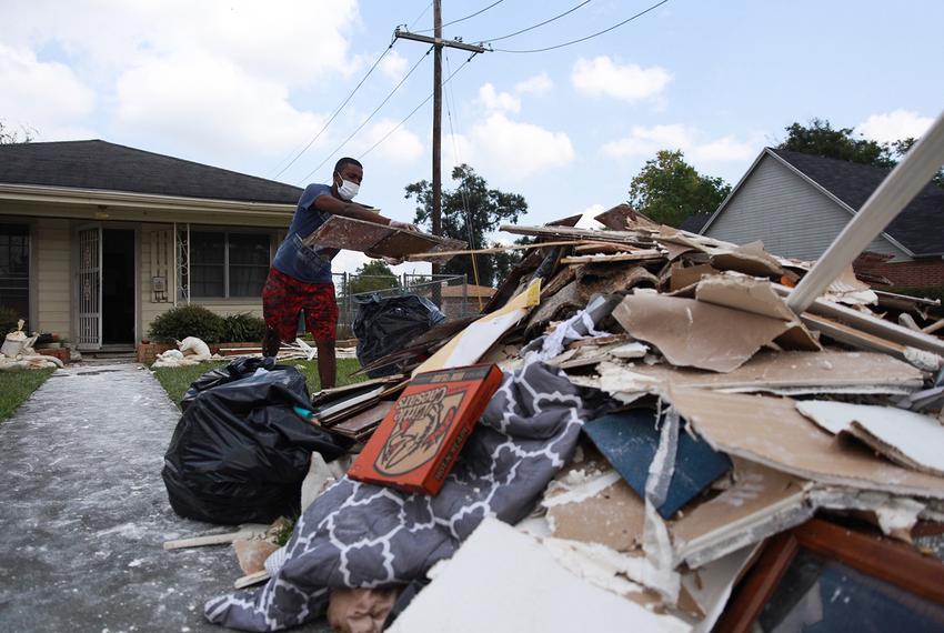 Myles Broussard tosses pieces of drywall into a pile of trash and storm debris outside his home in Beaumont, Texas on Sept. 4, 2017. 