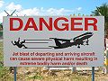 sign warning people that standing too close to the airport fence on Maho Beach can be dangerous